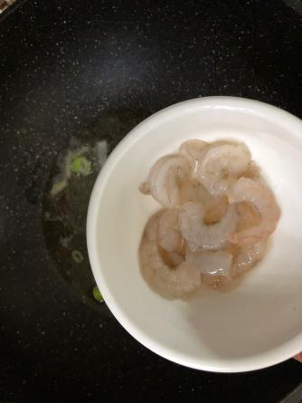 海鲜疙瘩汤,锅中放入食用油,葱花爆锅,放入虾仁翻炒;