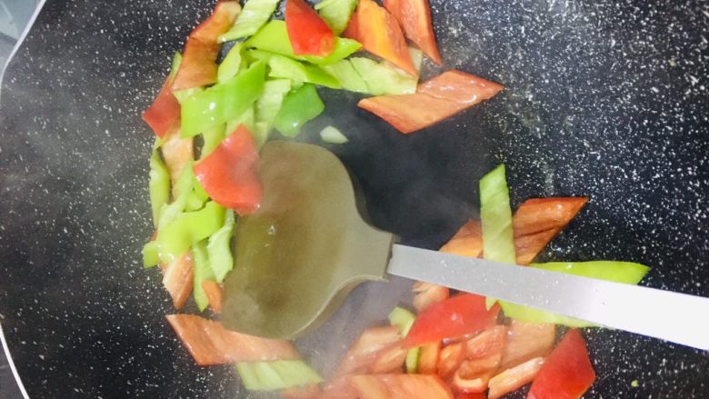 彩椒鸡蛋,油热后,一汤匙清水和青红椒片迅速入锅翻炒30秒