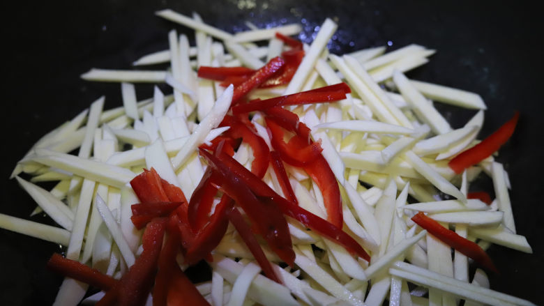 茭白炒鸡蛋,锅中留底油,倒入茭白和红椒丝翻炒。