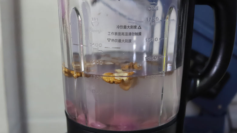 紫薯核桃米糊,加水至破壁机的1000毫升刻度线,破壁机的杯体上都会标着热饮最高刻度线,一般在1400毫升的位置,每个品牌和型号的标注都不一样,打热饮之前一定要仔细看一下,不要加入太满的水。