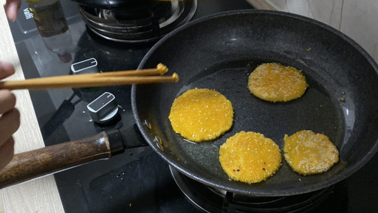 美味南瓜饼,在平底锅中加入食用油,待油温七八分热的时候,将压好的饼子放入锅中两面炸至金黄捞出,控油过后放入盘中。