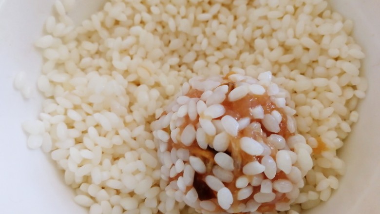 香菇鸡肉糯米蒸丸子,糯米去掉水份,虎口挤出丸子,放在碗里滚一圈,使丸子均匀沾上糯米。