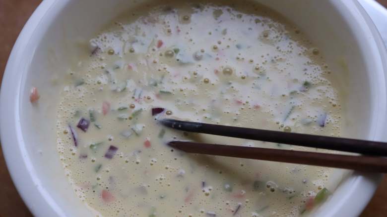 火腿鸡蛋饼,加入少许清水,把所有食材搅拌成面糊,最终面糊的状态为可以流动的稀面糊状就可以,如果只做的过程中发觉面糊太稠,可以中途添加少量的水稀释,不影响,面糊过于浓稠,摊出来的鸡蛋饼就会比较厚。