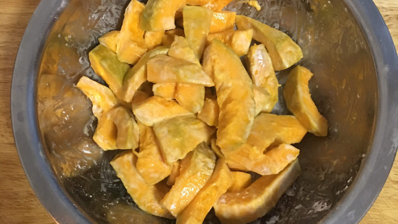 咸蛋黄南瓜,抓匀;同时小平底锅放入2碗油,开火加热到约150度左右(筷子沾湿后放入油中过几秒才开始冒小泡泡的程度)