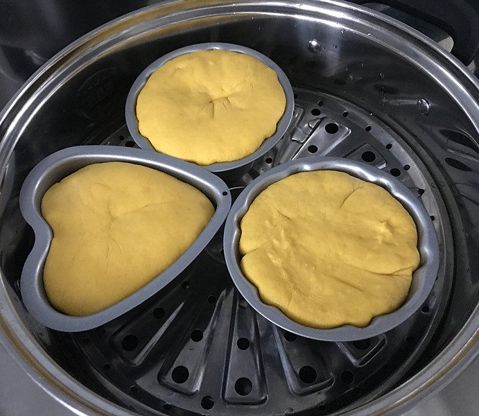 南瓜豆沙馒头,蒸锅中加入适量冷水,将做好的馒头生胚放入锅中,三层刚好,室温发酵至模具的8~9分满