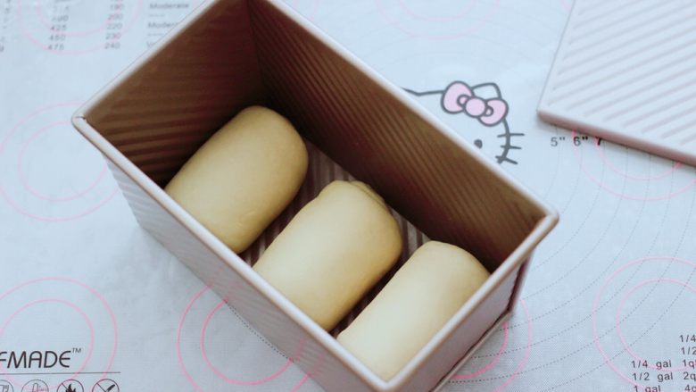 波兰种牛奶吐司,依次做完3个吐司胚,把卷好的吐司胚放入学厨吐司盒里。