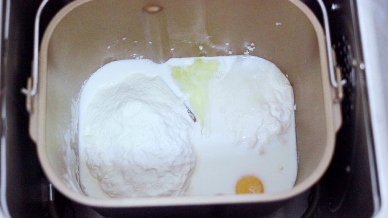 波兰种牛奶吐司,把波兰种和主面团的食材,全部倒入面包桶里,启动面包机,揉面一个程序。