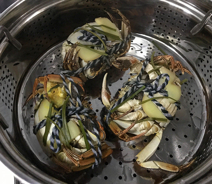 清蒸螃蟹,开小火蒸,待听不到螃蟹响动后,再转大火蒸12分钟左右