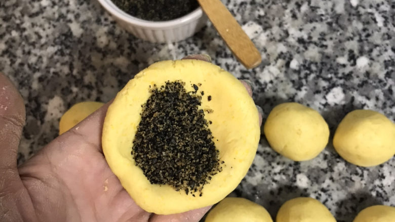 南瓜芝麻饼,舀入一匙内馅;