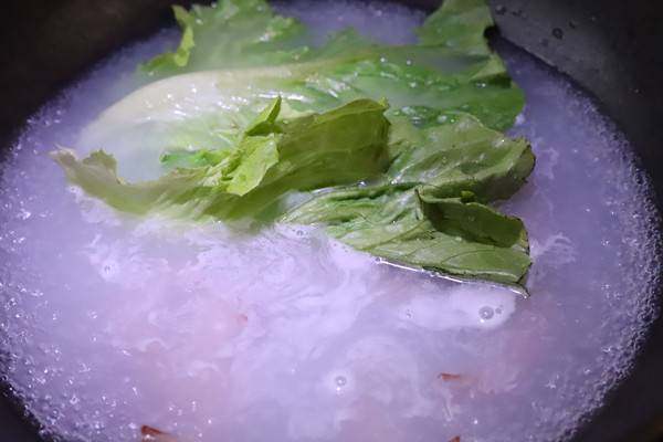鲜虾拉条子,将煮好的拉条捞出来,装入碗中,锅中的面汤不要倒掉,加入少许盐,加入虾和生菜烫熟,鸡蛋可以另外用一口小锅煮熟。