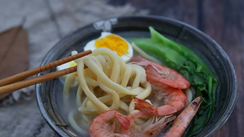 鲜虾拉条子,将面汤浇在面条上,摆上煮熟的鸡蛋,生菜,鲜虾,就可以开吃了。