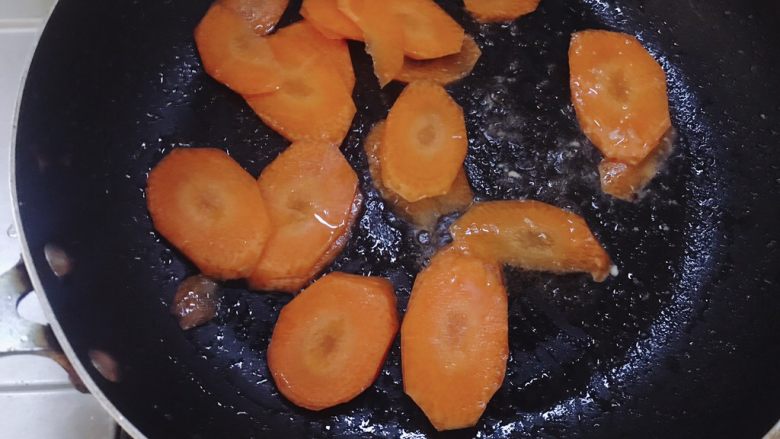 杏鲍菇炒肉片,锅里放少许油,先放入胡萝卜翻炒,胡萝卜比较难炒软所以最先下。