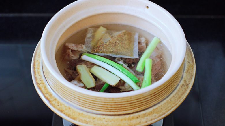 萝卜牛腩煲,再放入葱段和姜片,放入炖牛肉调料。