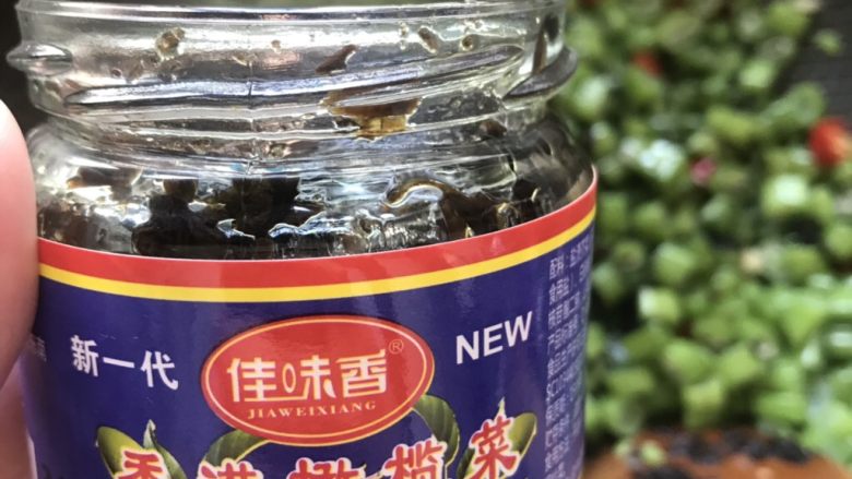 橄榄菜炒四季豆,倒入适量的<a style='color:red;display:inline-block;' href='/shicai/ 2862'>橄榄菜</a>继续翻炒,加入一点点的热水焖煮2-3分钟。