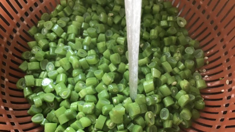 橄榄菜炒四季豆,捞出四季豆用冷水进行冲洗,这样做能保持脆爽。