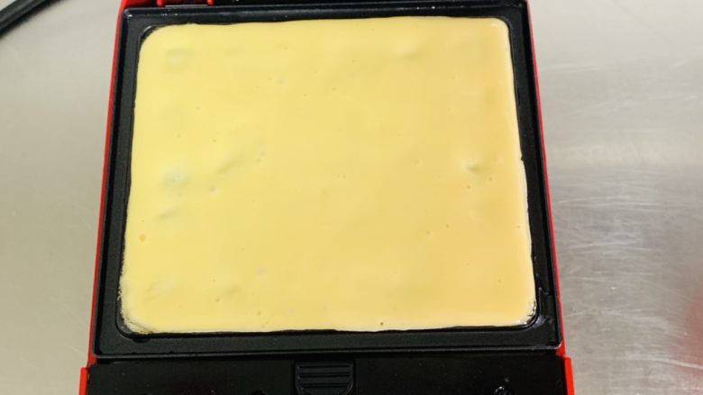 华夫饼,用刮刀轻轻刮平表面,缺的地方再倒入一点点的面糊补上。