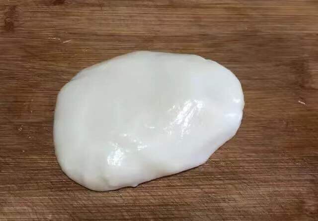 麻薯肉松吐司蛋卷,5、然后,戴上手套将黄油揉进蒸好的糯米粉浆中,使其形成一个光滑的糯米团,表面覆盖保鲜膜避免风干,放到一旁冷却。