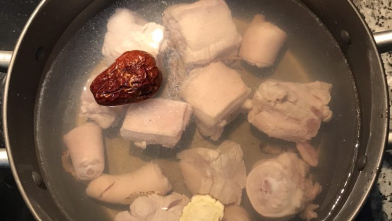 猪蹄莲藕汤,摆入当归、沙蔘和红枣,加入7分满的水,大火煮滚;