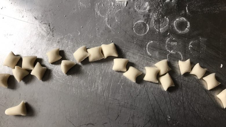 小羊肖恩馒头,取白色的面团排气搓成条,用刮刀切成黄豆大小的颗粒