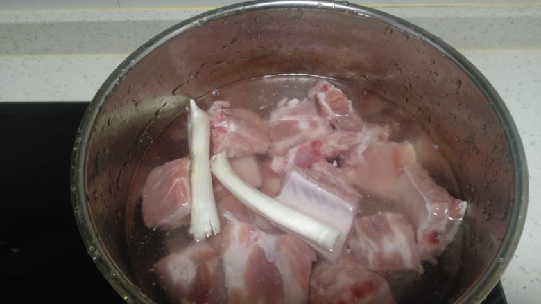 排骨豆角焖面,锅中放入适量清水,放入排骨,加入2段葱,大火煮开