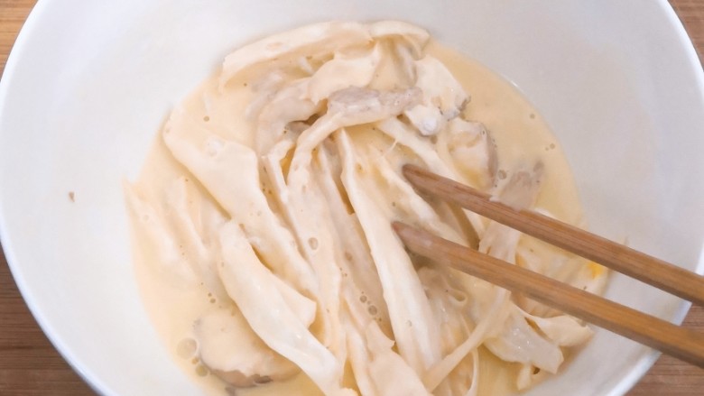 油炸杏鲍菇,用筷子,翻拌均匀,让每根杏鲍菇,都粘上面糊,备用