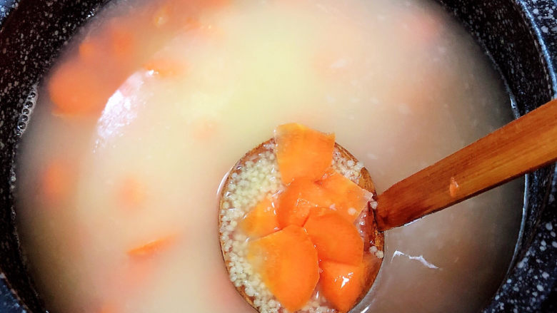 胡萝卜小米粥,加入胡萝卜,搅拌均匀。
