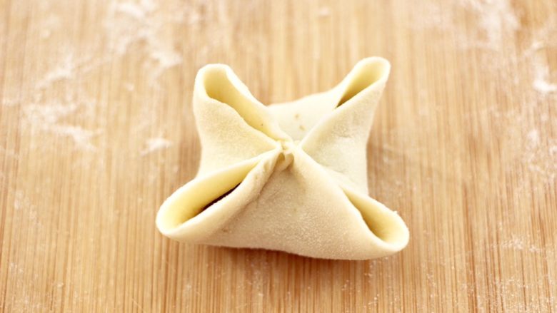 四喜饺子,把饺子皮的中间部分捏紧,如图。