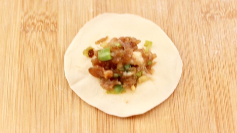 四喜饺子,取一个饺子皮,上面放入适量馅料。