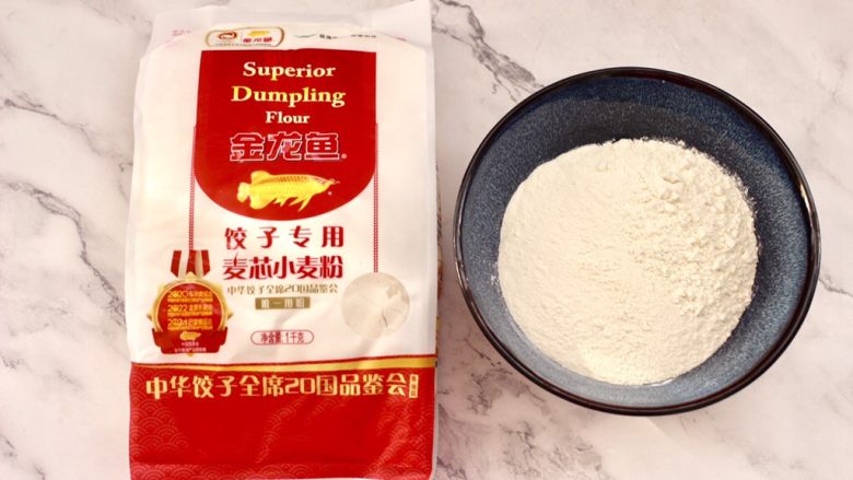 四喜饺子,把金龙鱼饺子专用麦芯小麦粉称重后,放入一个大一点的容器里,金龙鱼饺子粉源自麦芯精华,灰分低,色泽自然,饺子更亮白,和面的时候更柔和,擀皮还不回缩哟。