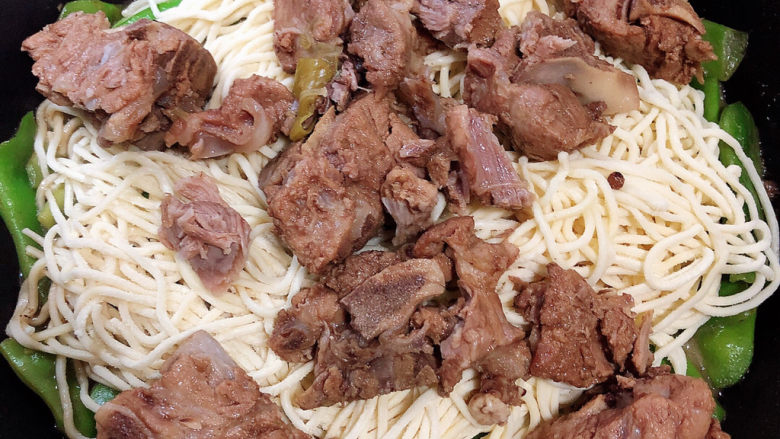 排骨豆角焖面,再铺上一层排骨。盖上锅盖,中火焖5分钟。