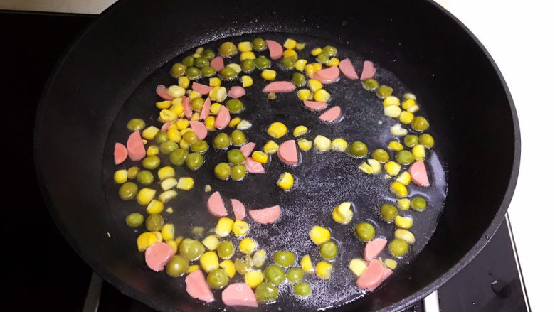 豆腐蒸蛋,加入青豆和甜玉米,翻炒1分钟