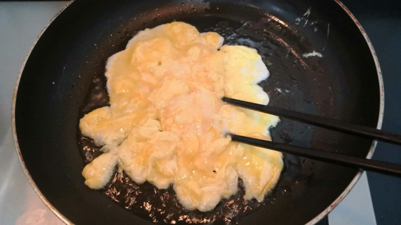 平菇炒鸡蛋,用筷子,划拨鸡蛋液,使鸡蛋液受热均匀,凝固断生