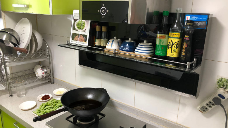 干煸四季豆,锅里倒入适量食用油,油烧到6成热。我是第一次做这道菜,可以把IPAD放在我家新买的布克新一代拦截式油烟机的置物台上边看食谱边做,真心方便,又不用担心iPad被油烟污染