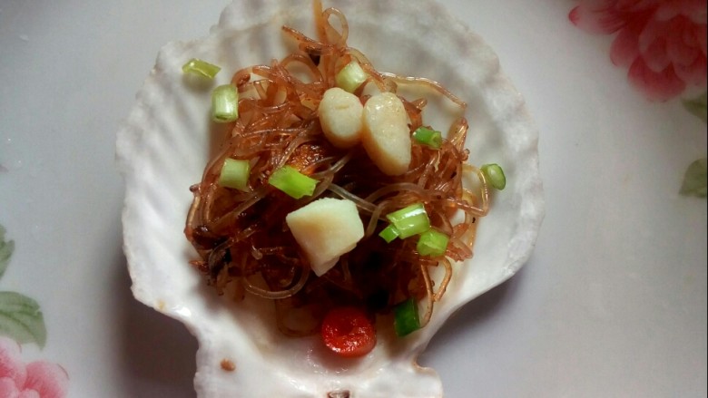 #冬日暖心菜# 川香粉丝蒸扇贝,扇贝壳装入炒香的粉丝,缀上扇贝,撒葱花。