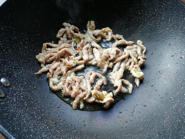 榨菜肉丝汤面,下入肉丝翻炒,将肉丝炒散开,翻炒至颜色变白。