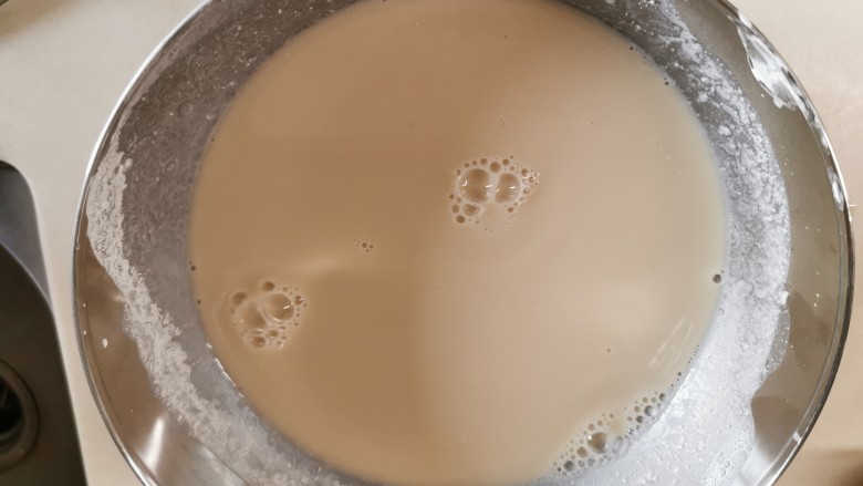 爽滑马蹄糕(红豆糕),把放凉后的糖水倒进之前开好的粉桨,慢慢的边倒进去边顺时针搅拌。直到均匀,用手直接摸一下底,看有没有沉淀。静待10分钟。