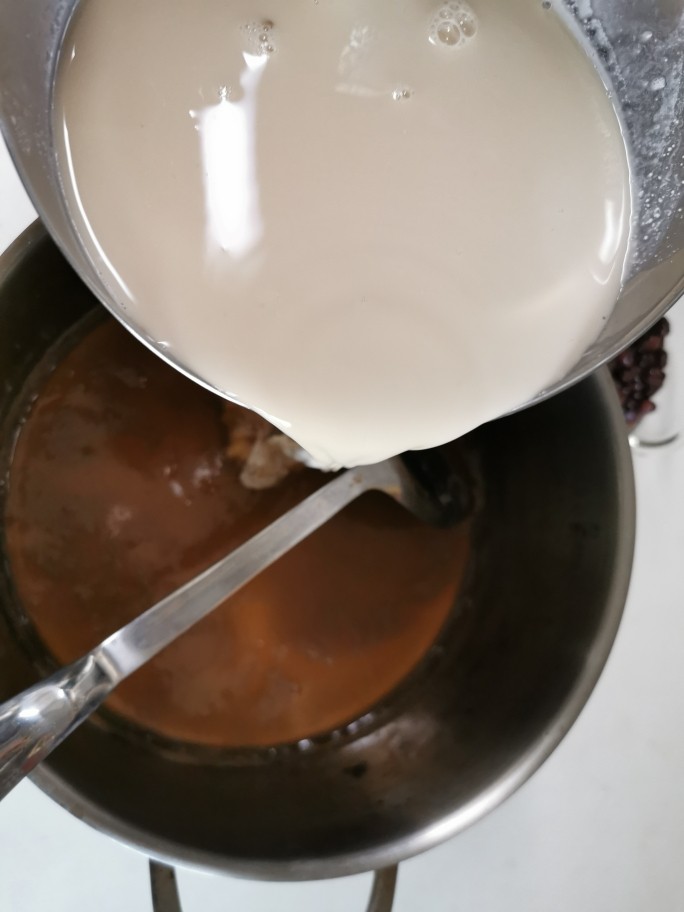 爽滑马蹄糕(红豆糕),等十分钟后,刚刚混一起的粉桨,已经分层了,把上面的三分之一,倒进锅里,慢火不停搅拌均匀,煮成马蹄糊。关火等马蹄糊放凉,大概80度,再把温热的马蹄糊(熟桨)倒入剩下的三分之二粉桨(生桨)快速搅拌均匀。