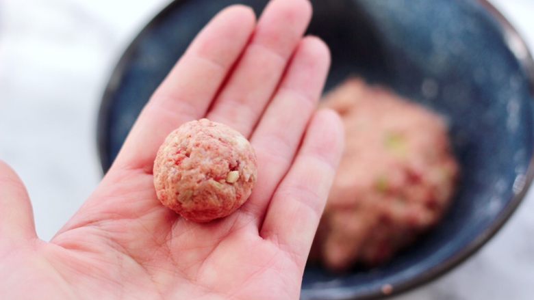 冬日暖心菜 手工牛肉丸子粉丝双色萝卜煲,用手把摔打好的肉馅,滚成大小一致的丸子,大小看个人喜好哈。
