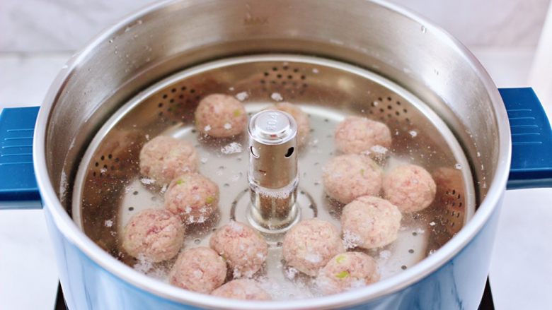 冬日暖心菜 手工牛肉丸子粉丝双色萝卜煲,臻米升降火锅里,倒入适量的清水,烧至五成热时,把做好的牛肉丸子一个个放入锅中。