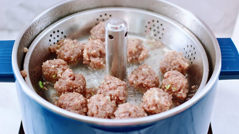 冬日暖心菜 手工牛肉丸子粉丝双色萝卜煲,打开火锅的升降功能,把蒸屉篮升起来,把煮熟的丸子取出一半,因为吃不了这么多,我用了一半,臻米得益于一键升降式的设计,随意升降火锅和蒸煮都是特别方便的哟。