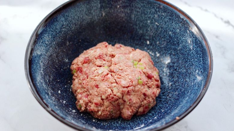 冬日暖心菜 手工牛肉丸子粉丝双色萝卜煲,把所有的食材用手反复摔打成团,我摔了差不多80多下左右,摔的时间越久,做出来的丸子越口感筋道爽滑好吃。