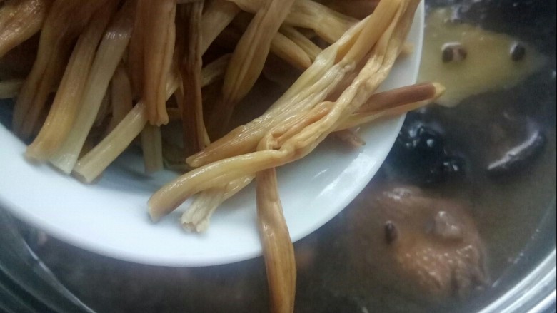 #冬日暖心菜# 鸡菇营养汤锅,放入泡发的黄花。