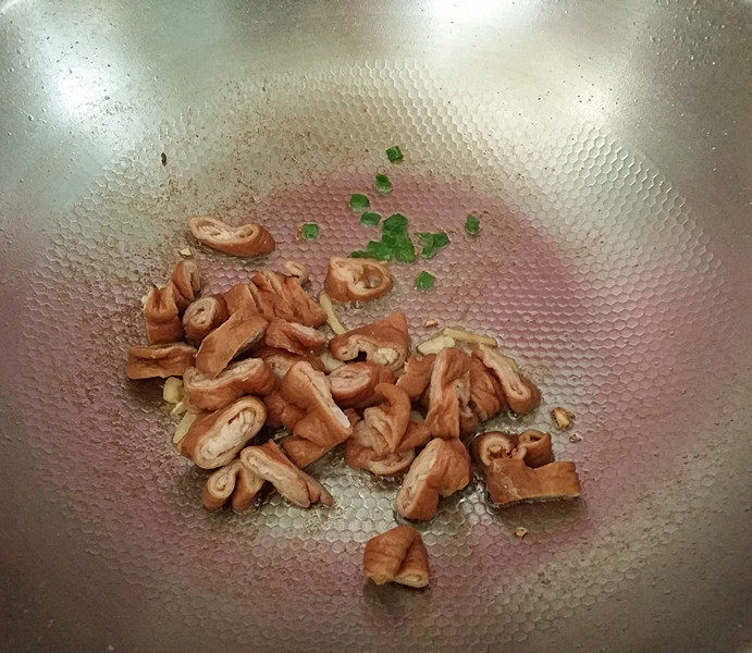 干煸肥肠,留底油爆葱姜蒜,再放入肥 肠煸炒,注:留少许蒜片备用