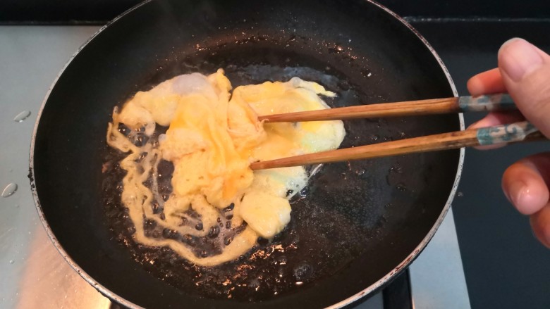 鸡蛋炒菠菜,用筷子,快速划散,使鸡蛋液,凝固断生