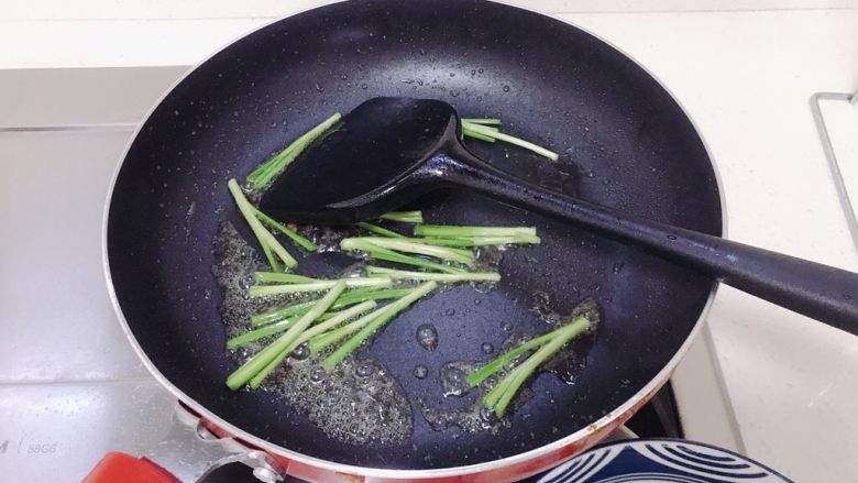韭菜炒豆芽,用锅里的油炒菜,先放入韭菜的头。