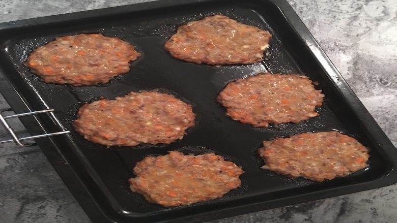 快手蔬菜肉饼减脂汉堡,肉饼烤好后将烤盘取出,将刚才切好的汉堡放入微波炉里稍微叮一下;