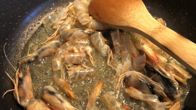 鲜虾什锦炒饭,锅里放多一些油,放入虾壳,炒出红油。炒的时候,把虾头部按压几下,把虾头里的膏要压出来。这是虾油的精华之处。大概要慢炒15-20分钟。中间油不够或者太少可以再加。