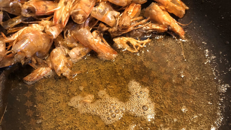 鲜虾什锦炒饭,炒至这个程度:油里有虾壳的红色,虾壳酥脆,并且可以闻到强烈的鲜味,这样虾油就炸好了。我们留住油在锅里,把虾壳捞出丢弃。