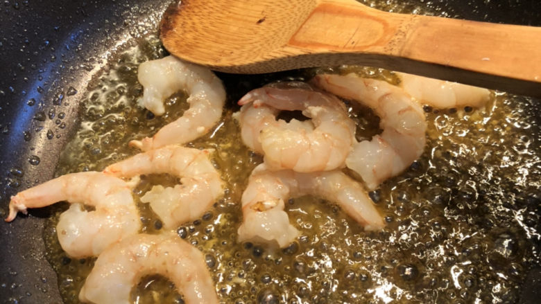 鲜虾什锦炒饭,接下来在虾油锅里放入虾仁,翻炒几下。