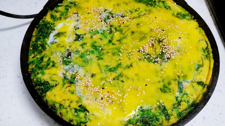 玉米面、小芹菜、鸡蛋饼,煎至定型，打入<a style='color:red;display:inline-block;' href='/shicai/ 9'>鸡蛋</a>，撒入芝麻